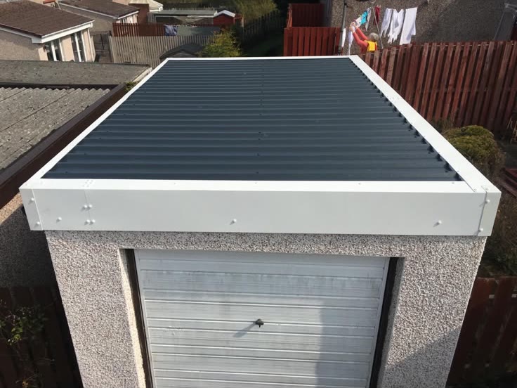 New sheet roof and white trims on a garage by LA Roofing