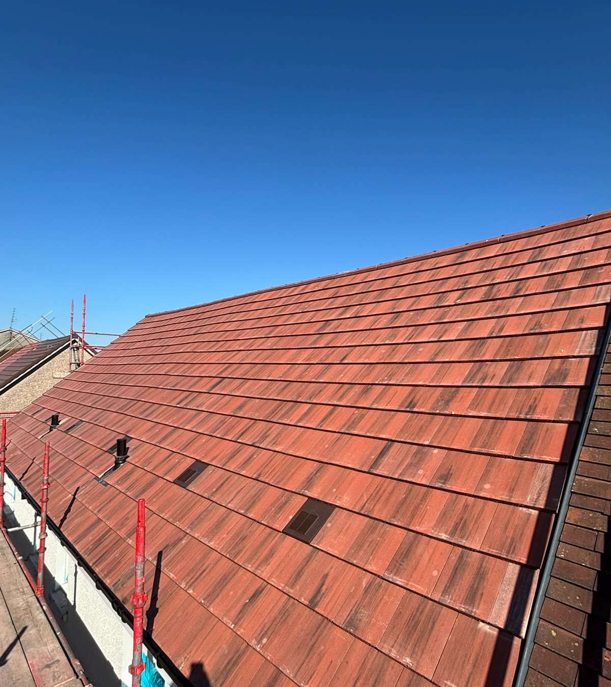 New red tiled roof against a clear blue sky