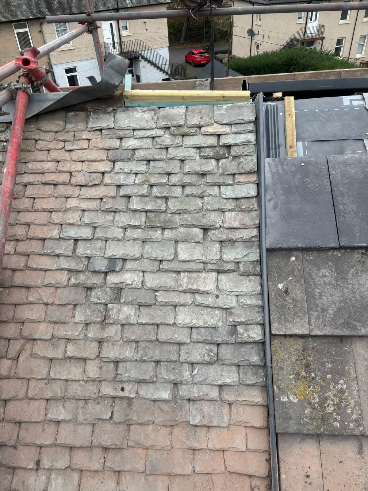 Slate roof repair with fresh slates blended into the existing roof
