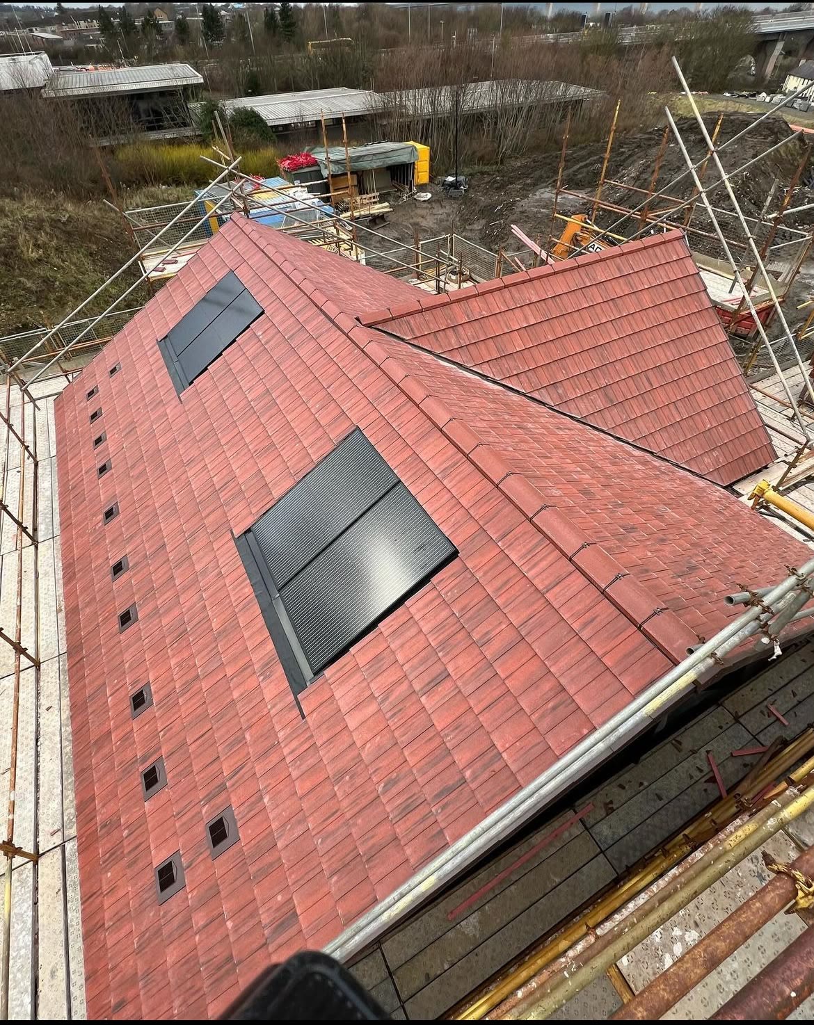 Newly tiled red roof with integrated solar panels by LA Roofing